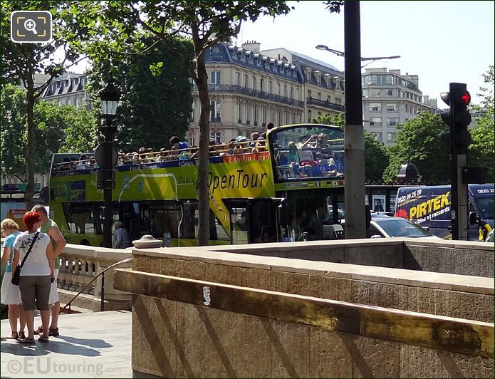 Tourists on open top deck of Paris tour bus