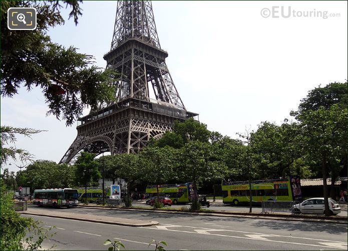 Three OpenTour buses at a stop by Eiffel Tower