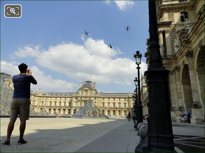 Tourist photographing fly by at Musee du Louvre 