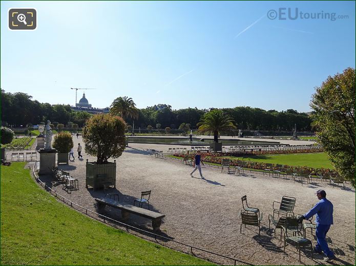 Worker organising green chairs in Jardin du Luxembourg