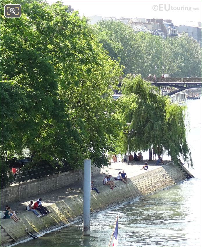 People sitting by water at Square du Vert Galant